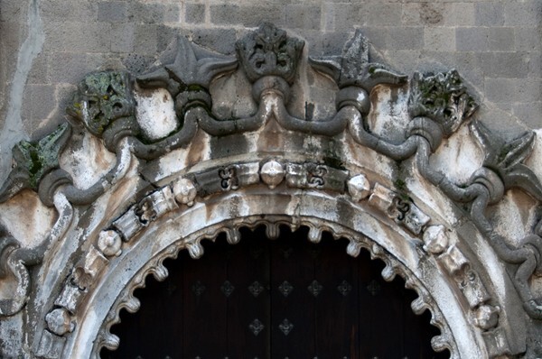 Porciúncula portal archivolt - San Miguel Arcángel, façade, portería, crosses & porciúncula door