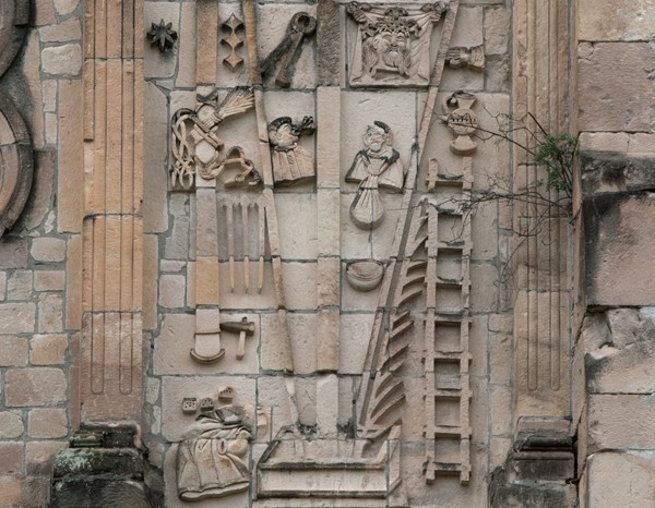 San Juan Bautista, N façade, Arma Christi right of oculus, details - San Juan Bautista, North façade