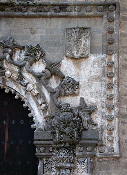 Porciúncula portal, alfiz (right) - San Miguel Arcángel, façade, portería, crosses & porciúncula door