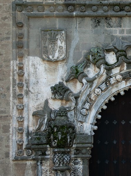 Porciúncula portal, alfiz (left) - San Miguel Arcángel, façade, portería, crosses & porciúncula door