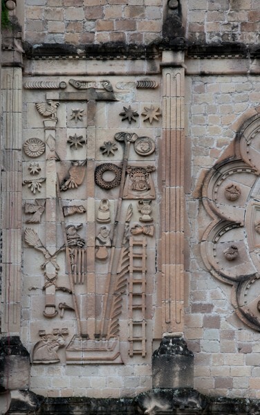 San Juan Bautista, N façade, Arma Christi left of oculus - San Juan Bautista, North façade