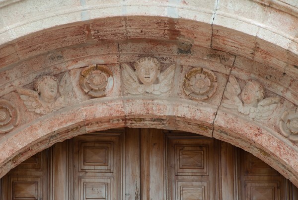 Façade portal archivolt, seraphim & rosettes - Façade, exterior buttressing, lateral portal, open & posa chapels, atrio & cross