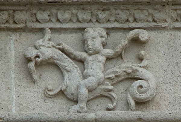Façade architrave relief, putto aloft hippocamp - San Juan Bautista, façade, portería & posa chapels