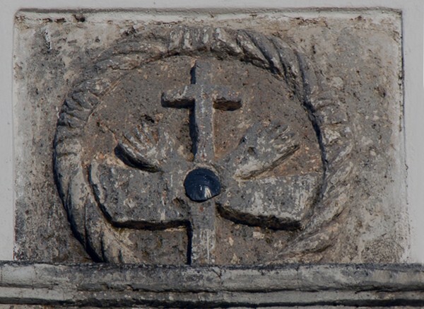 San Felipe, façade entablature, Franciscan insignia with obsidian disk - San Felipe de los Alzati, Michoacán