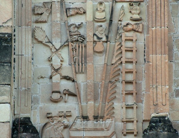 San Juan Bautista, N façade, Arma Christi left of oculus, details - San Juan Bautista, North façade