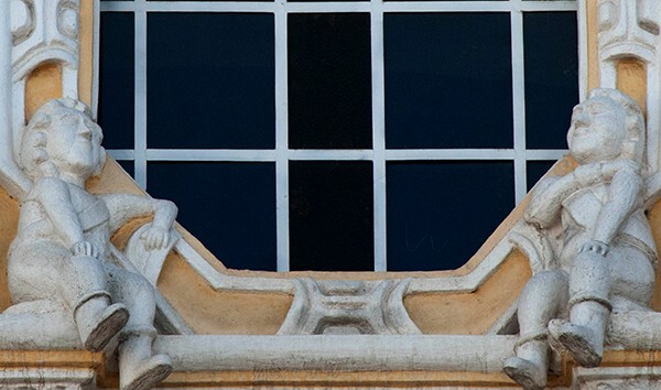 Lateral façade, window base putti - La Tercera Orden