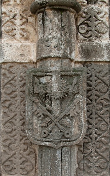 Porciúncula portal, left pilaster closeup - San Miguel Arcángel, façade, portería, crosses & porciúncula door