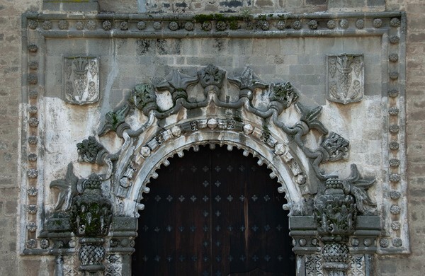 Porciúncula portal, alfiz - San Miguel Arcángel, façade, portería, crosses & porciúncula door