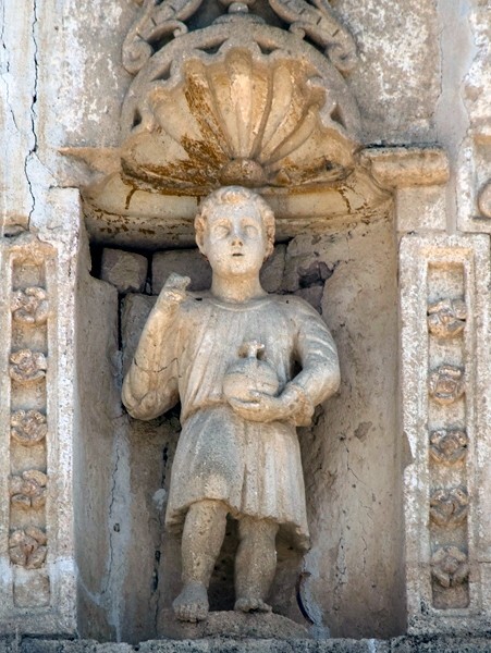 Façade niche sculpture, Christ Child - Façade, exterior buttressing, lateral portal, open & posa chapels, atrio & cross