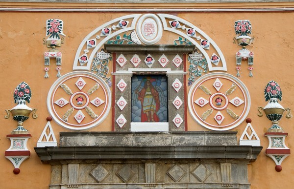 San Miguel, façade, choir loft window & reliefs - San Miguel