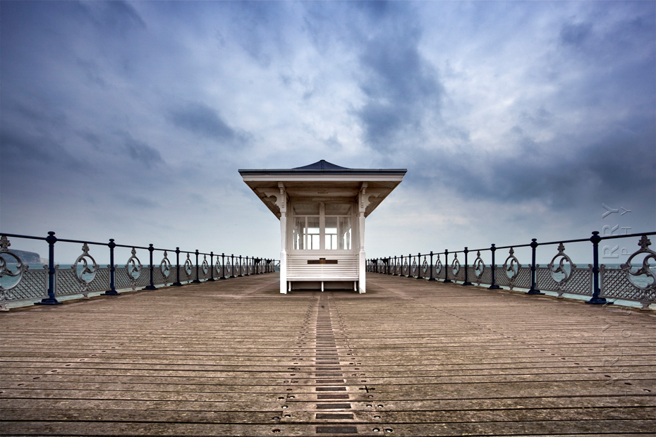 Swanage pier shelter under an atmospheric sky