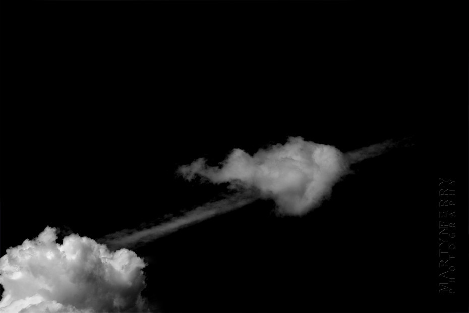 Fine art photography of clouds floating in black nothingness