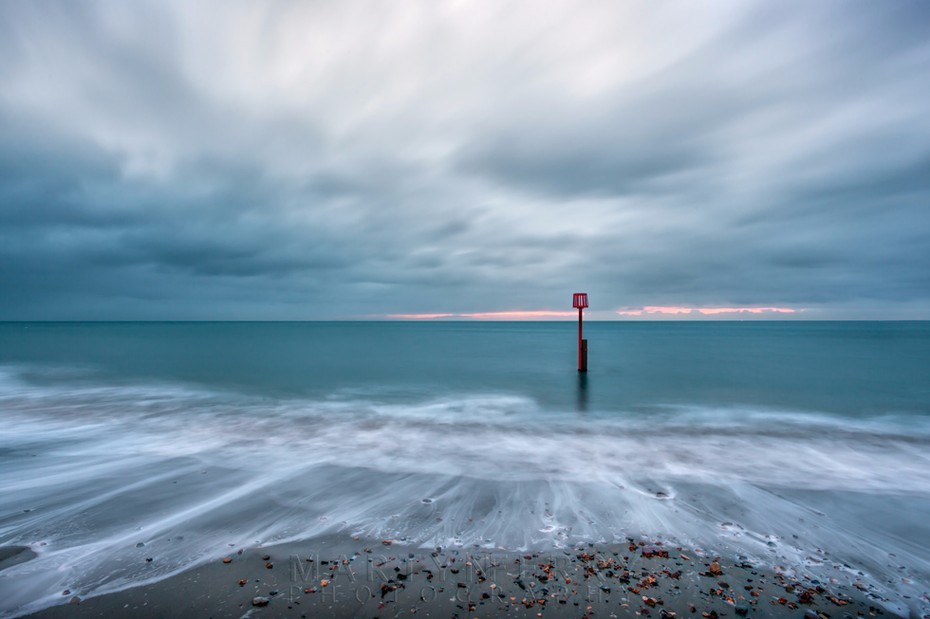 Swanage beach dawn clouds over a blue sea