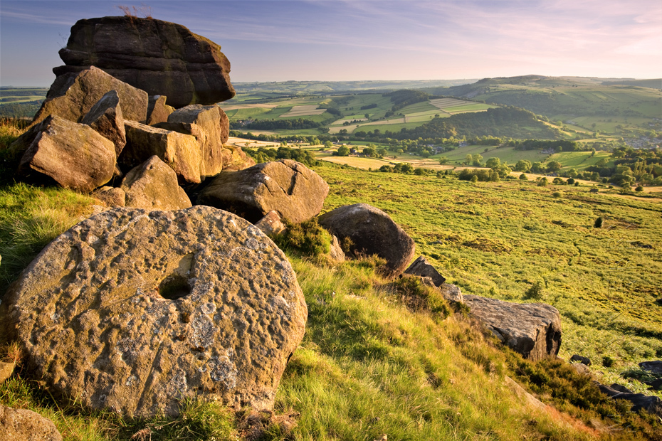 Image of millstones in the warm evening sunlight at Baslow Edge
