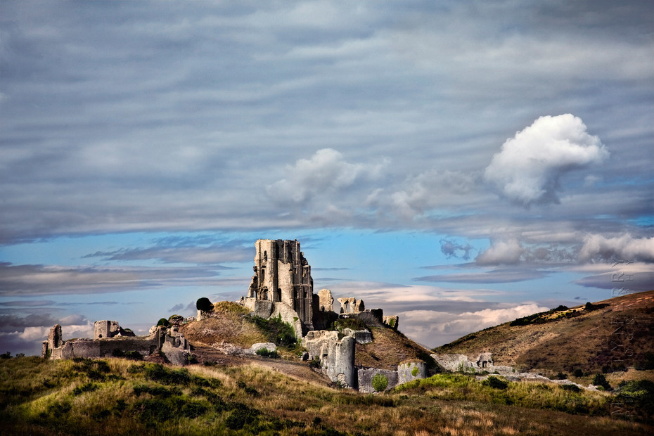 Beautiful Corfe Castle ruins in Dorset under light clouds.