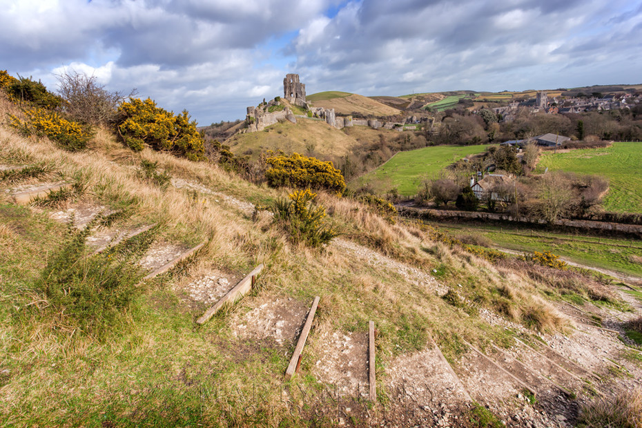 Looking towards Corfe Castle ruins under billowy clouds