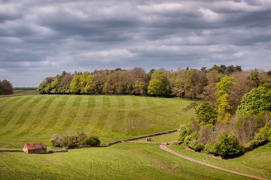 Hatherop Estate in the afternoon sunshine under stormy clouds