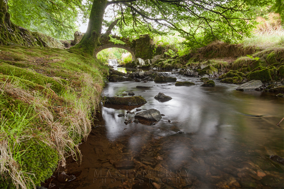 Robbers Bridge in Exmoor under the shady canopy of trees