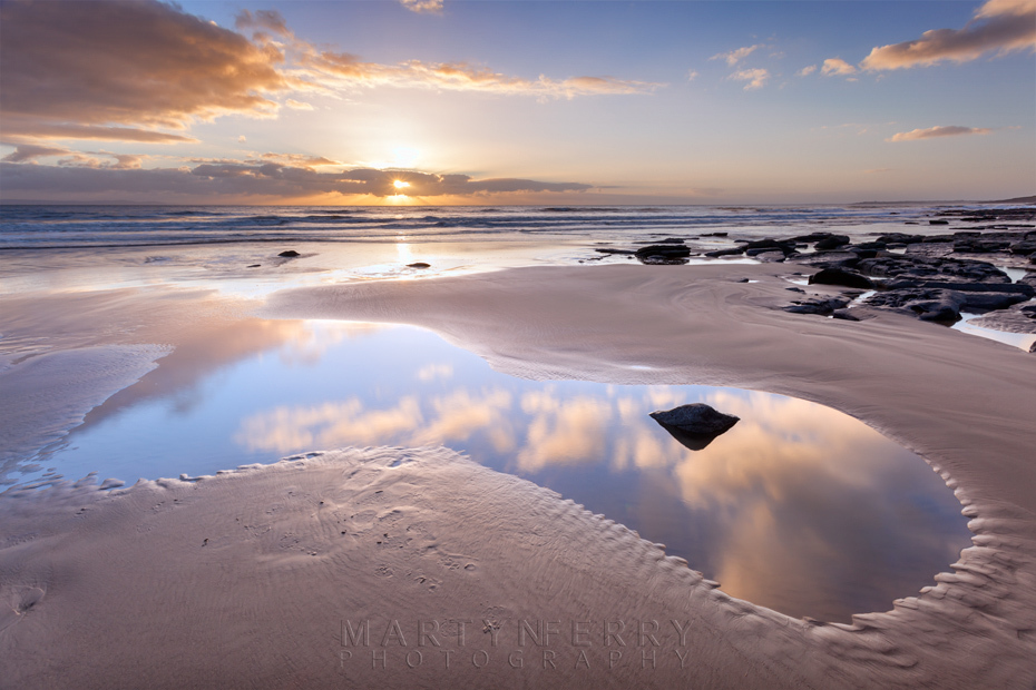 Beach pool reflection of the sunset clouds at Dunraven Bay