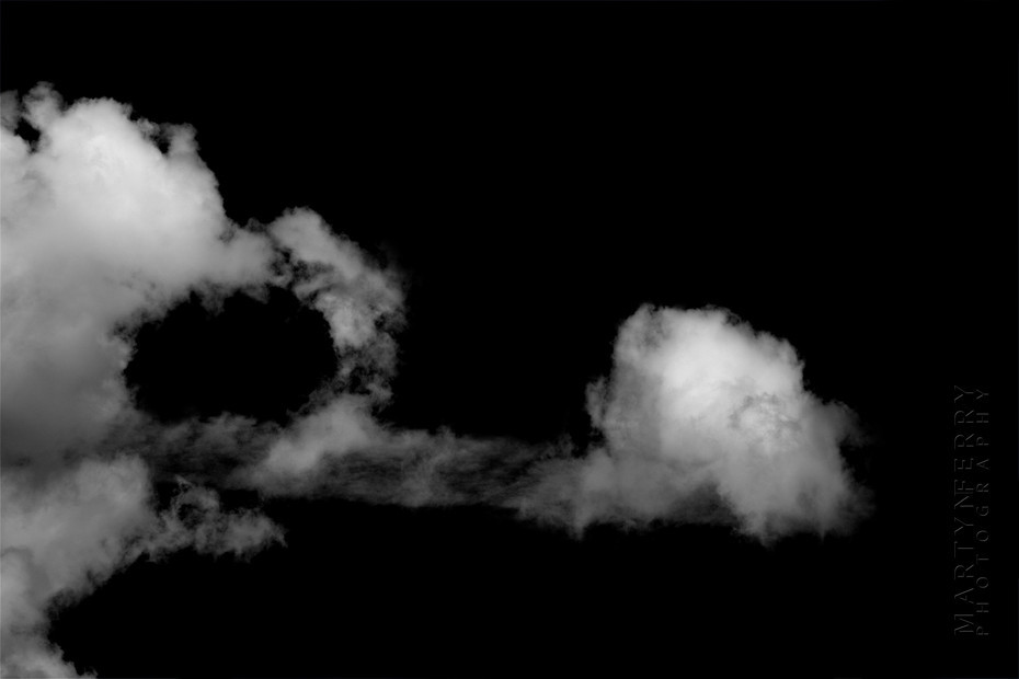 Fine art photography of clouds floating in black nothingness