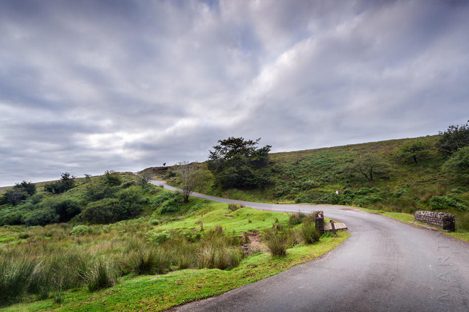 Winding lane through Exmoor moorland under clouds