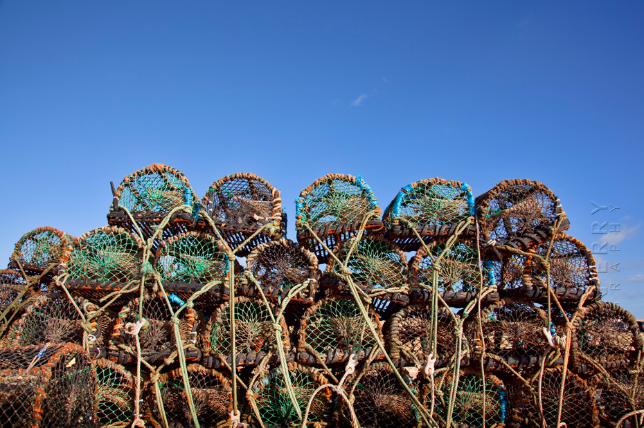 Stack of crab pots at Seahouses harbour under a clear blue sky