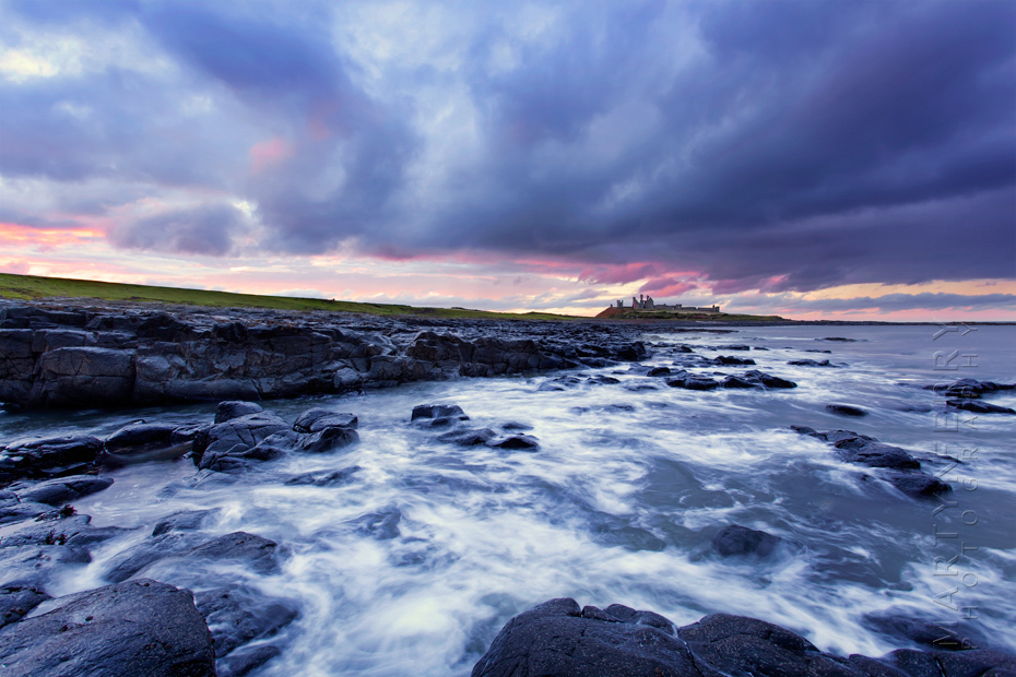 Stormy clouds at sunset over Dunstanbrugh Castle in Northumberland