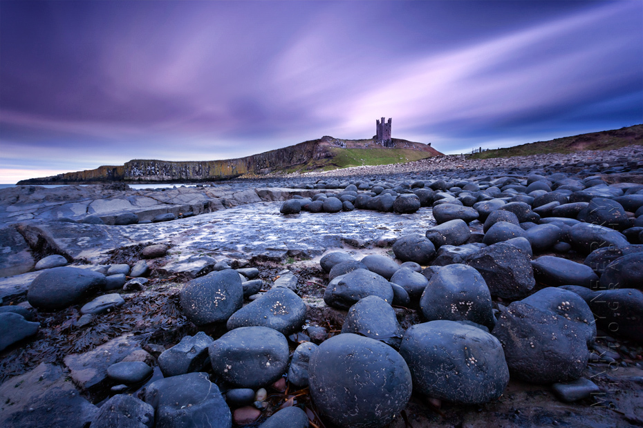 Dunstanbrugh Castle on a colourful stormy sunrise