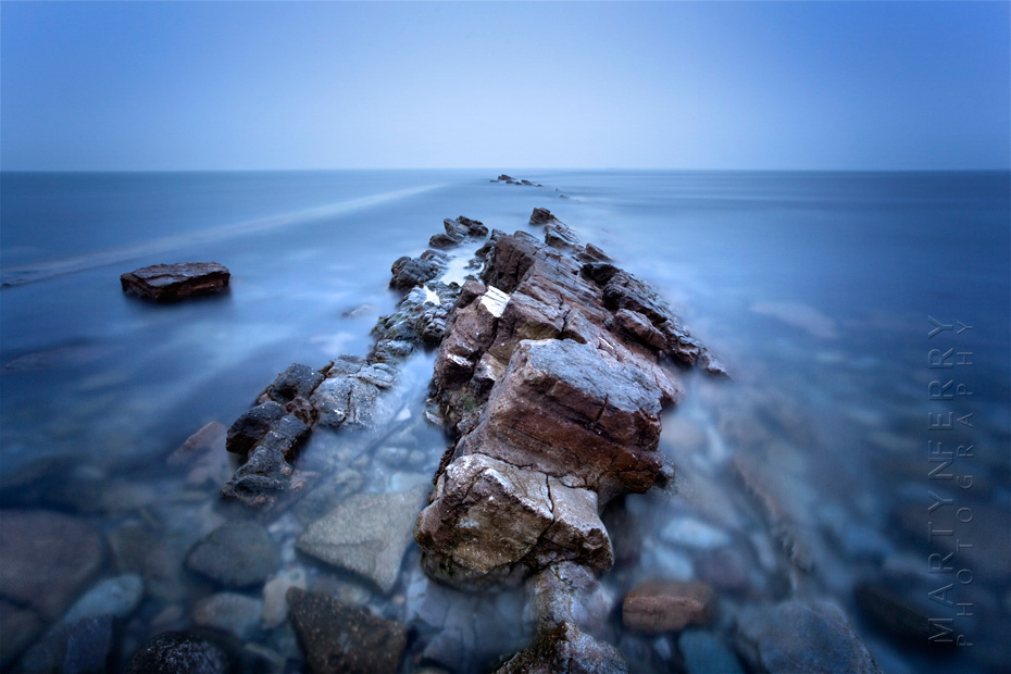 Spectacular cool blue image of Peveril Point rocks