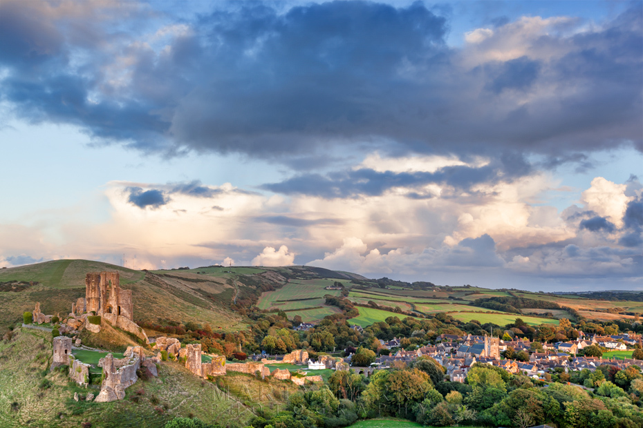 Sunset light over Corfe Castle ruins and village in Dorset