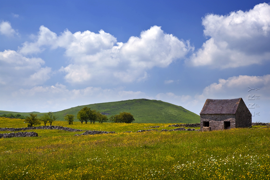 Beautiful Peak District image of barn and summer clouds.