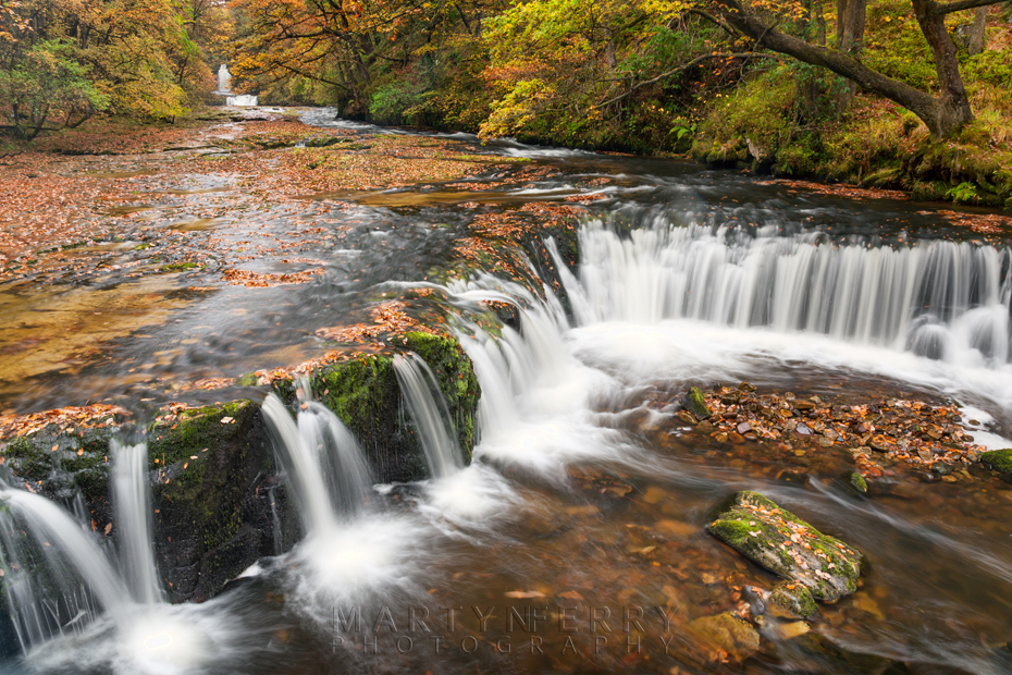 Horseshoe Falls beneath the colours of autumn in Wales