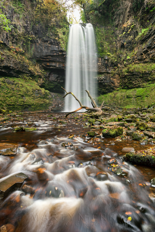 Henrhyd Falls and a cascade of water in the foreground