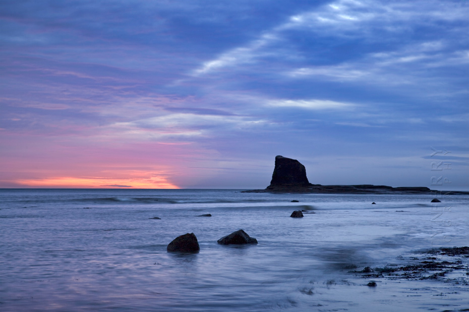 Black Nab under beautiful clouds and dawn light at Saltwick Bay