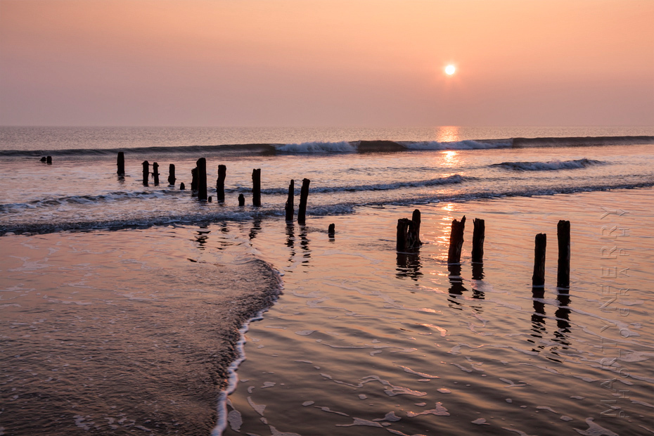 Sandsend groynes at sunrise in warm orange light