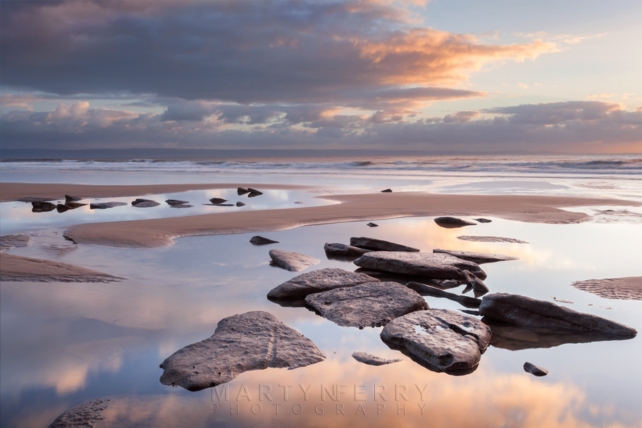 Rock pools reflect the setting sun at Dunraven Bay in Wales