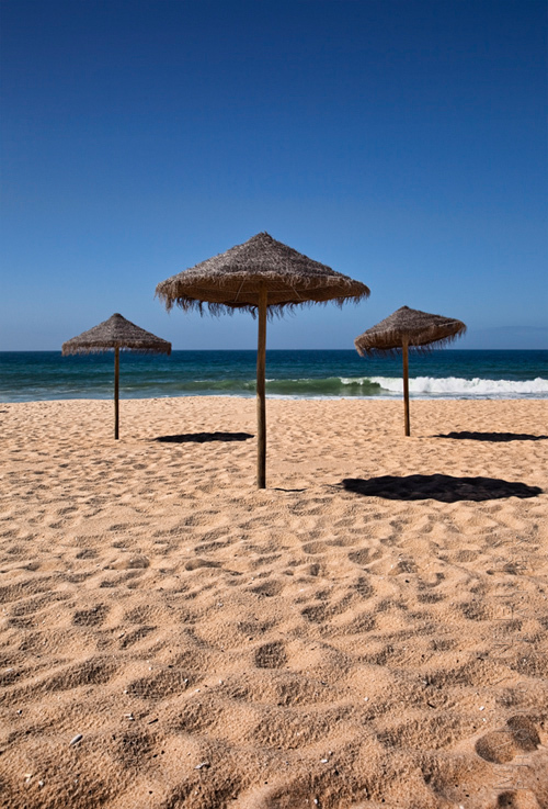 Beautiful beach image with straw umbrellas