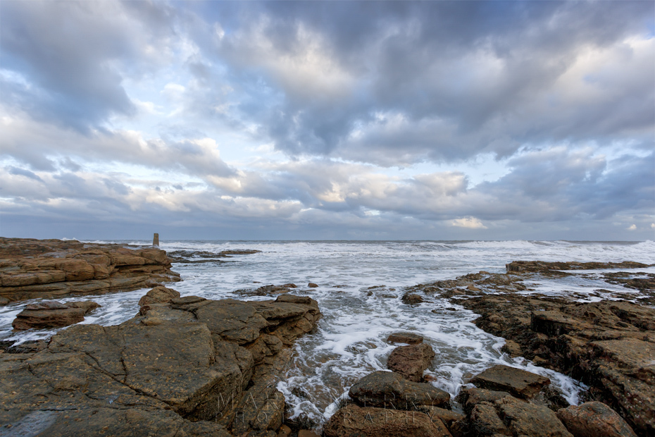St Mary's island shoreline under dramatic clouds