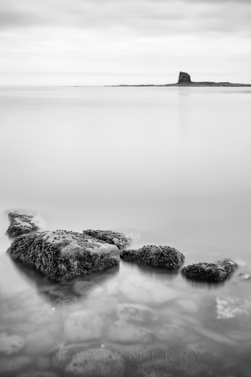 Saltwick Bay image in black and white of Black Nab and rocks