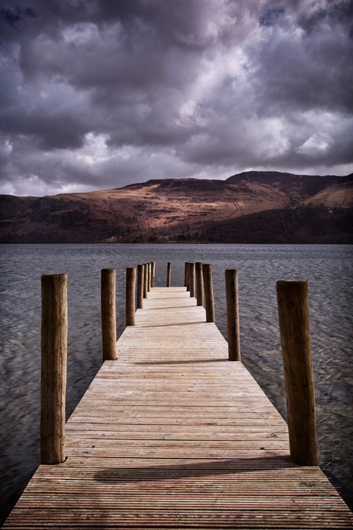 Brandlehow jetty in sunlight under stormy skies