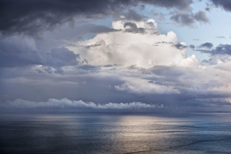 Photo of huge clouds over a calm ocean