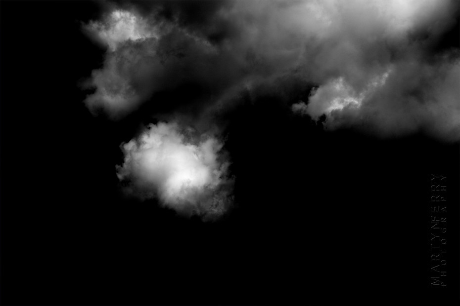 Fine art photography of clouds floating in black nothingness
