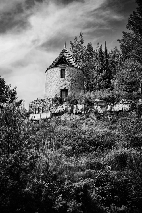 Ancient Lagrasse windmill and wispy clouds