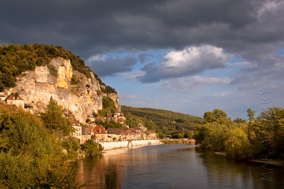 Warm sunshine on La Roque Gageac with stormy clouds above