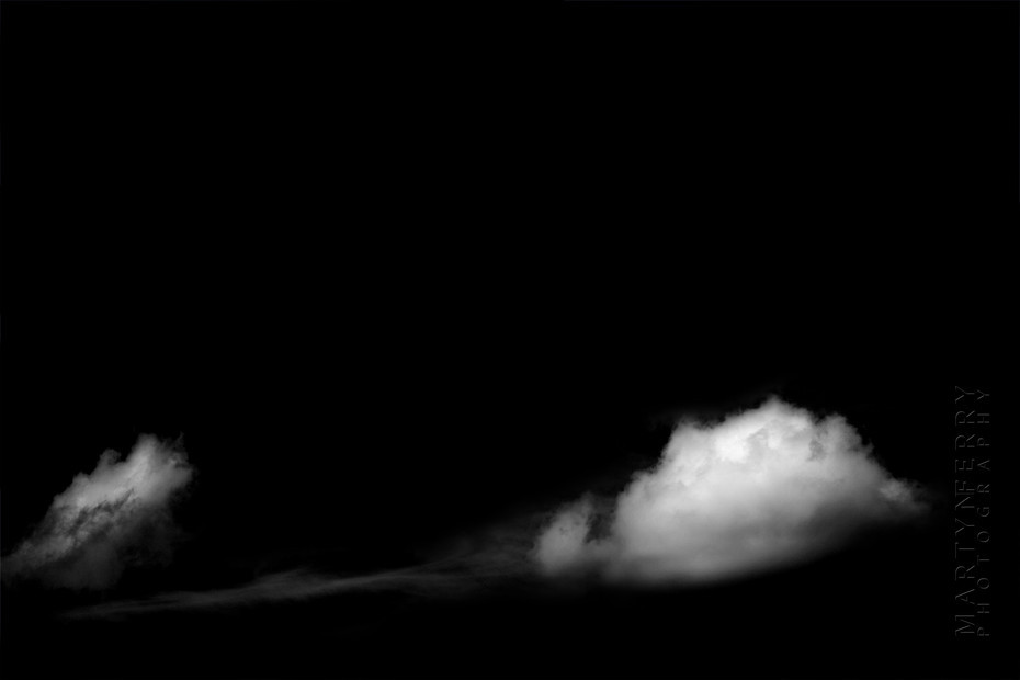 Fine art photography of clouds floating in black nothingness