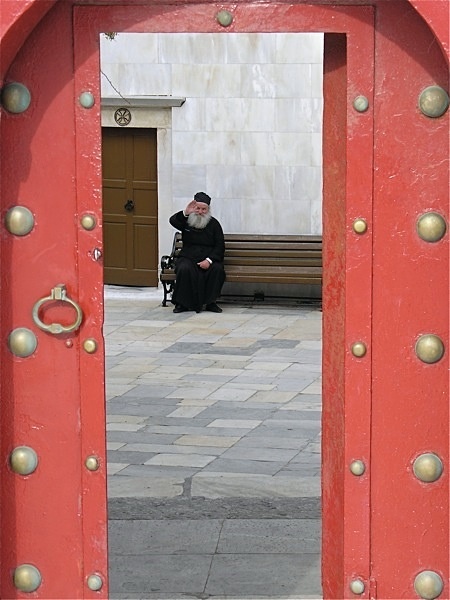 Monk  through red door - Greece