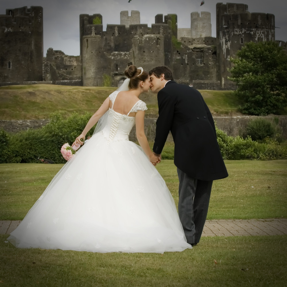 Bride and groom kissing at Caerphilly Castle - Wedding Photography at Caerphilly Castle